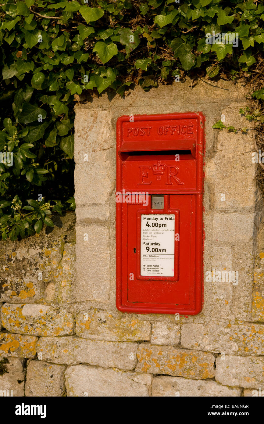 A red letter box in a wall marked Post office in a English Village Stock Photo