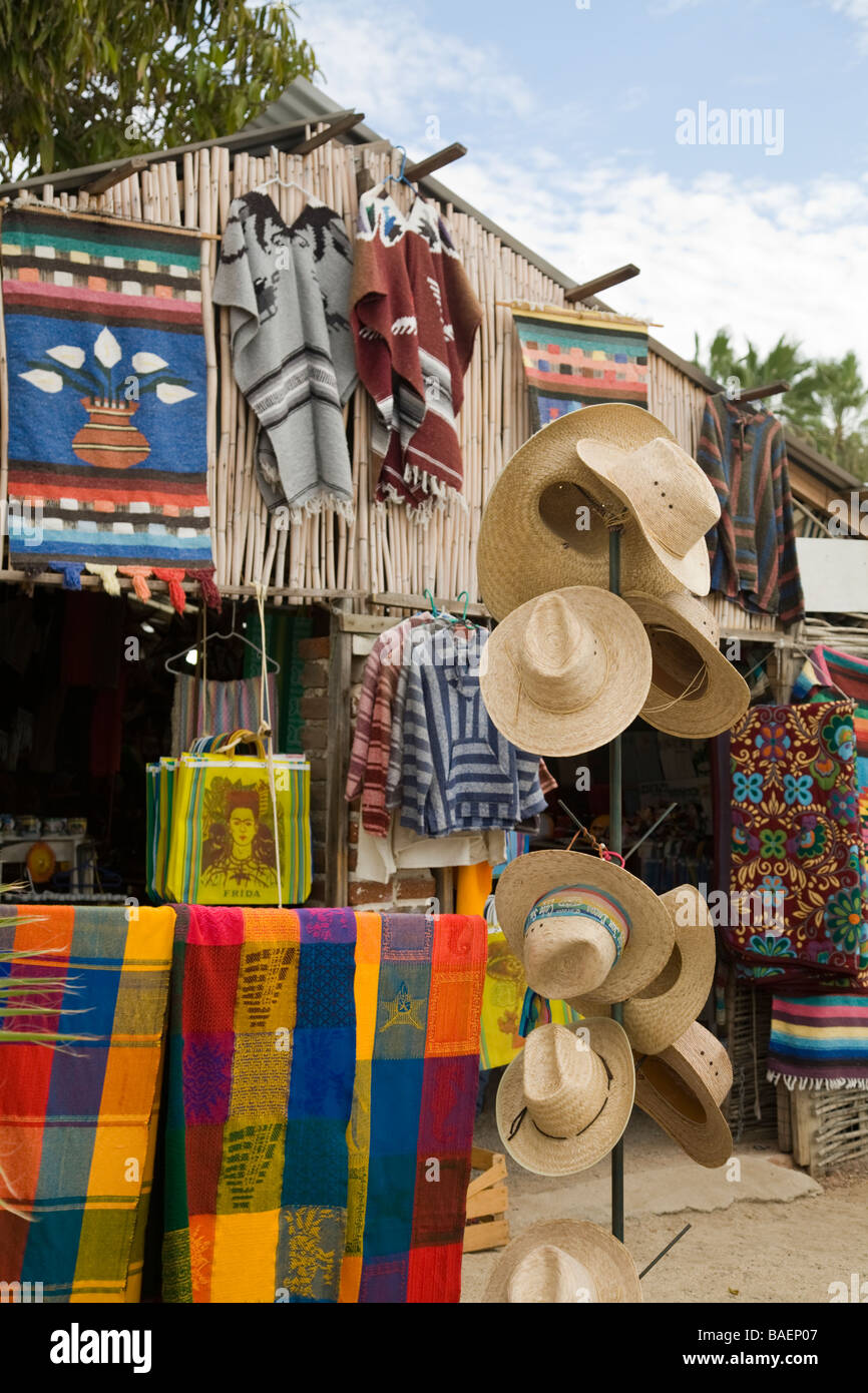 MEXICO Todos Santos Painted masks and straw hats hanging on display
