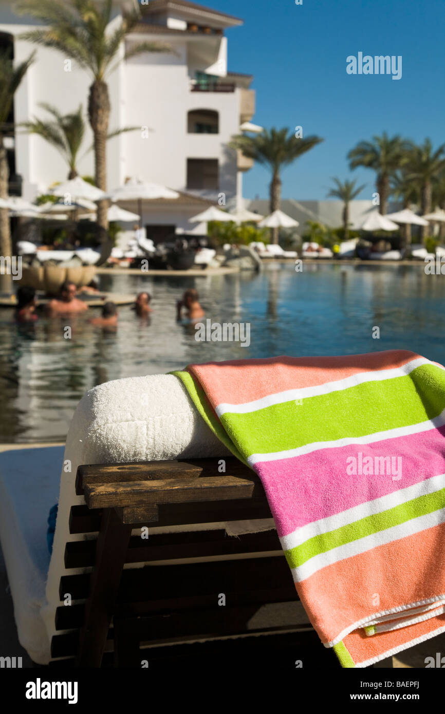 MEXICO San Jose del Cabo Striped beach towel draped over chaise lounge next to swimming pool at Cabo Azul resort Stock Photo