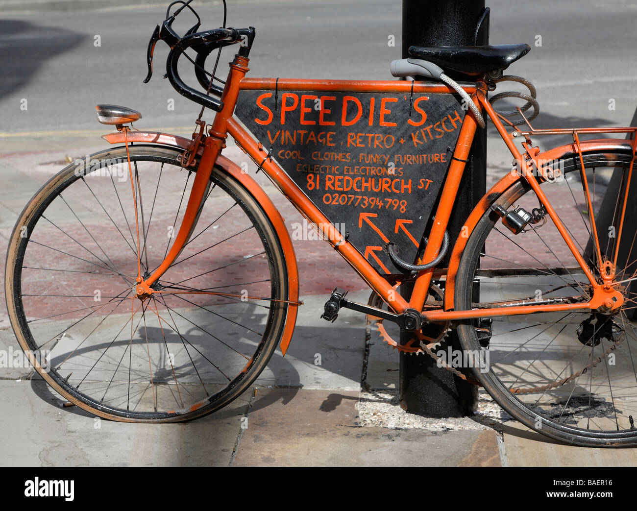 Orange bicycle advertising vintage retro clothing shop Stock Photo Alamy