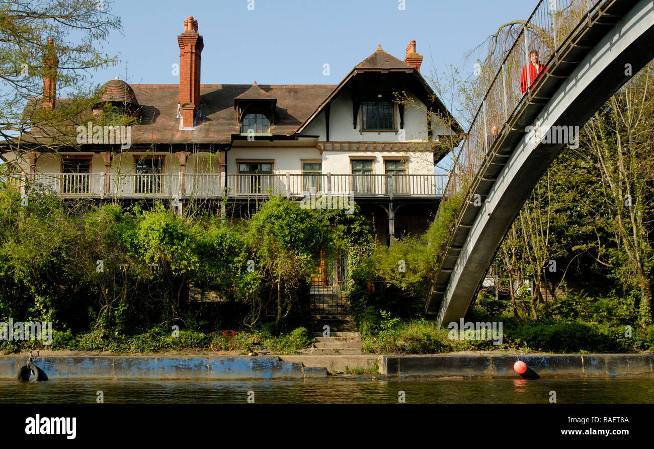 Eyot House and arced pedestrian footbridge on D'Oyly Carte Island in the middle of the River Thames at Weybridge, Surrey, Englan Stock Photo