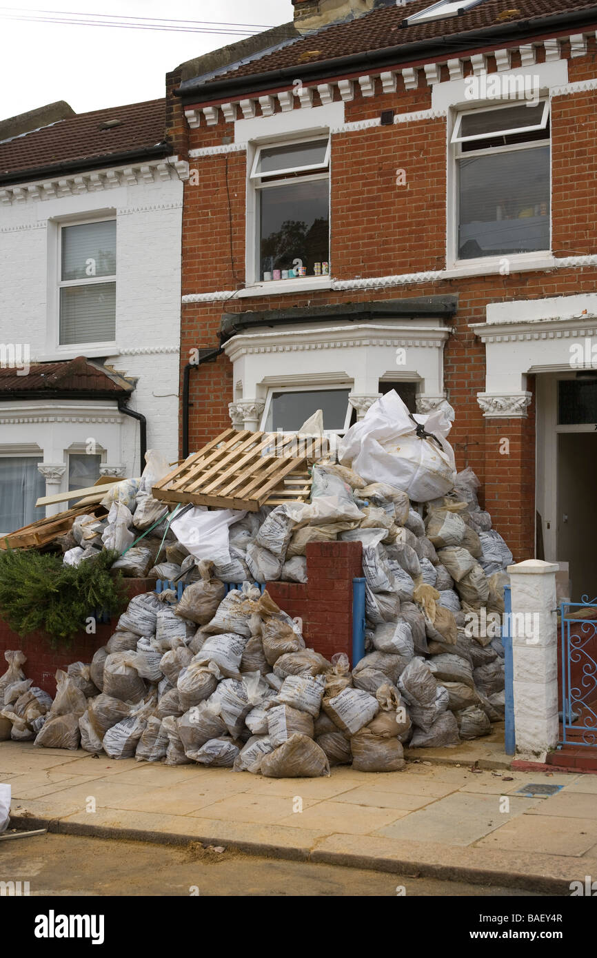 Bagged up builders rubble in sacks outside a house renovation project in south london Stock Photo