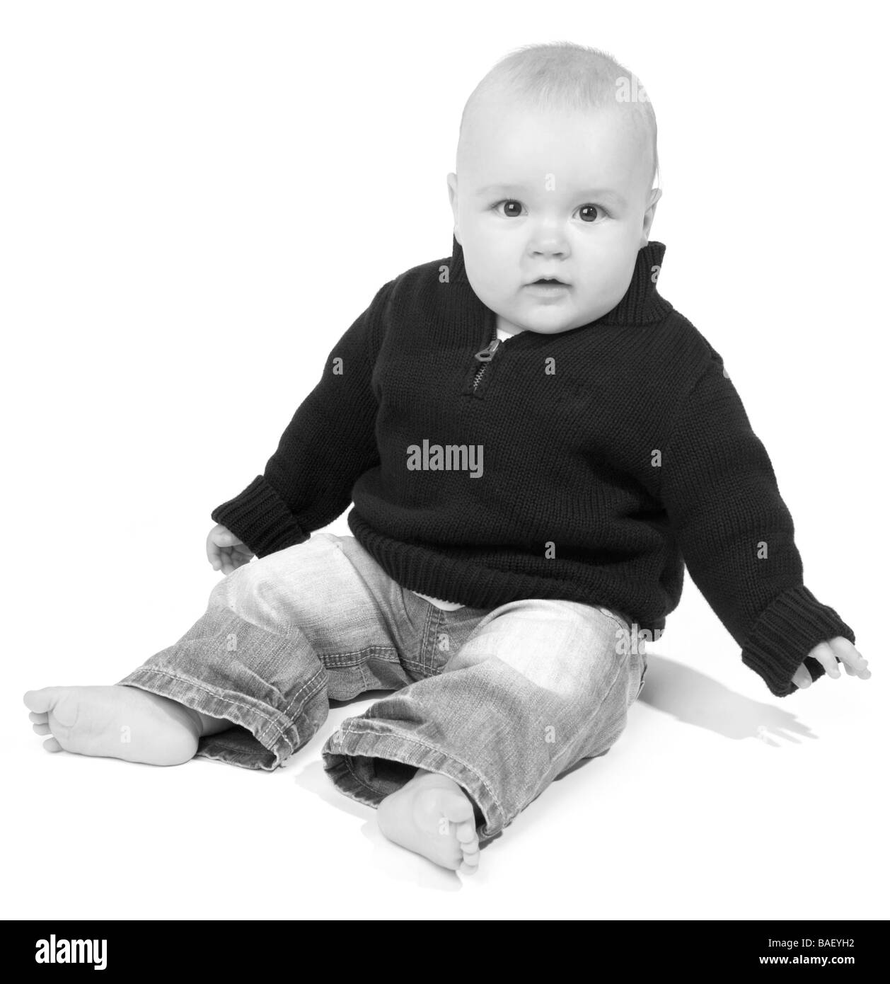 A baby sits on a white background Stock Photo