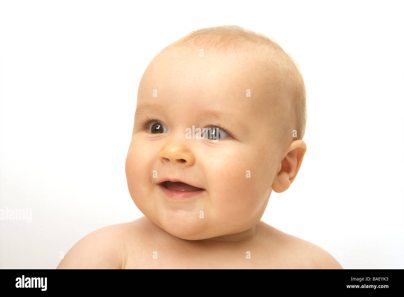 A happy smiling baby looks away on a white background Stock Photo
