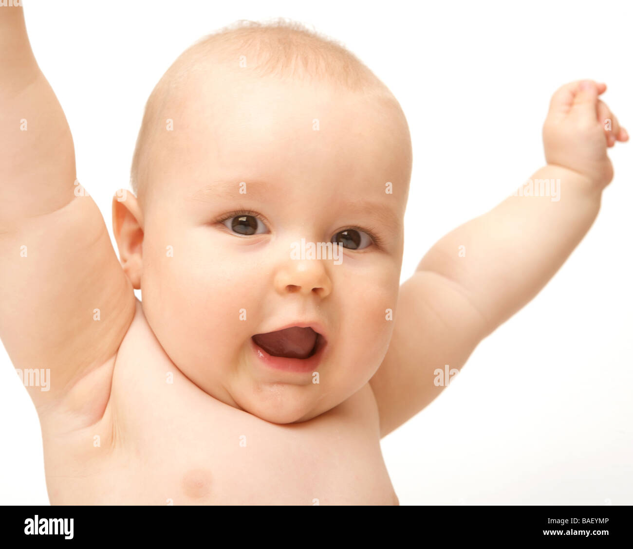A baby cheers with arms outstretched against a white backdrop wearing a nappy Stock Photo
