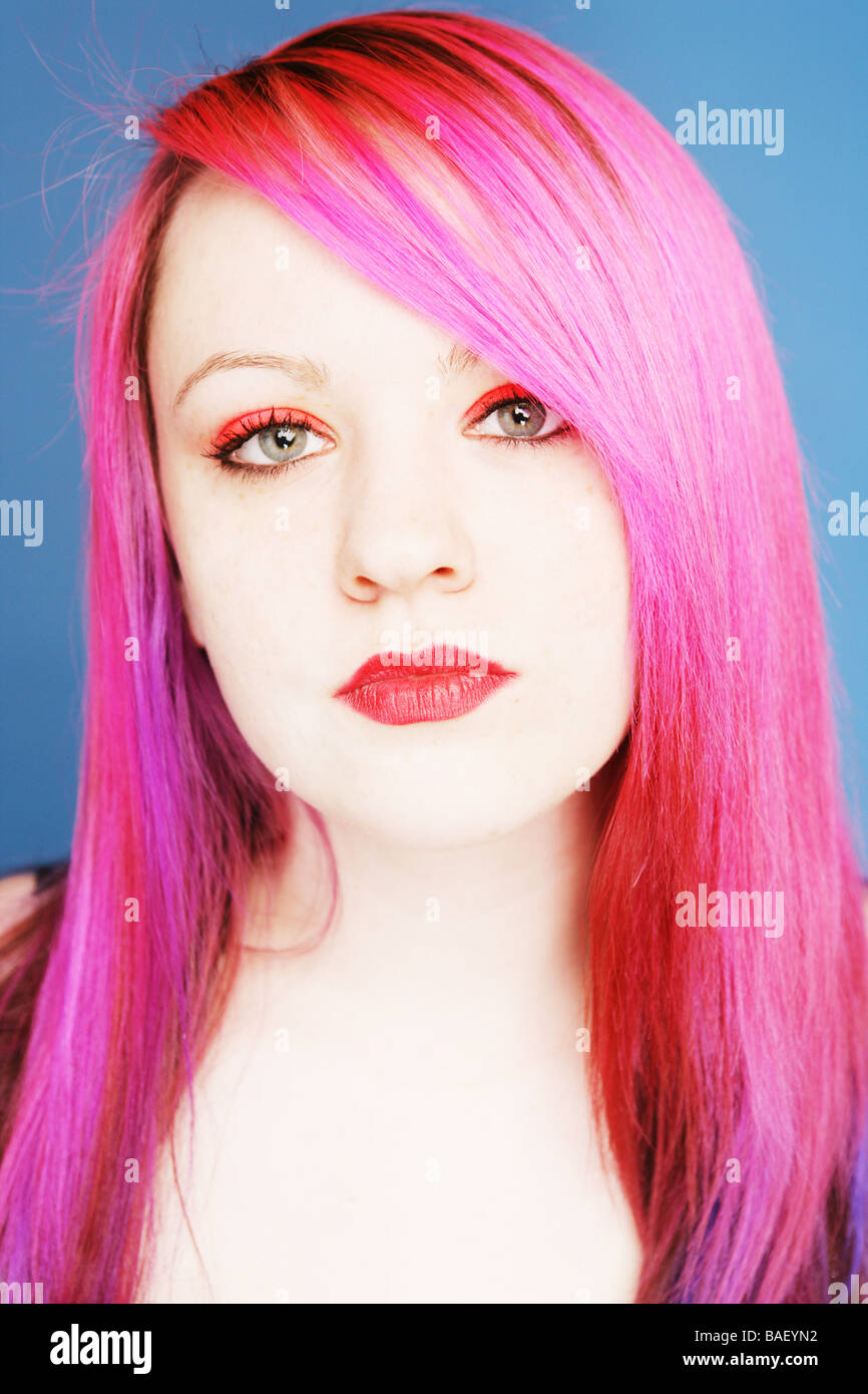 Young teen with bright pink hair and red lips looking straight at camera Stock Photo