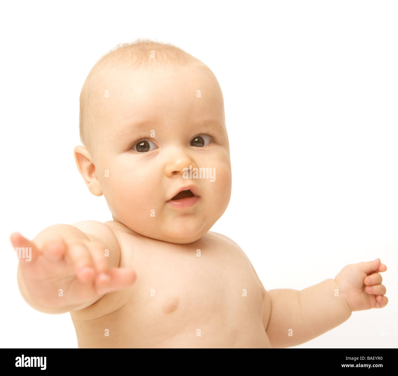 A baby points against a white backdrop Stock Photo