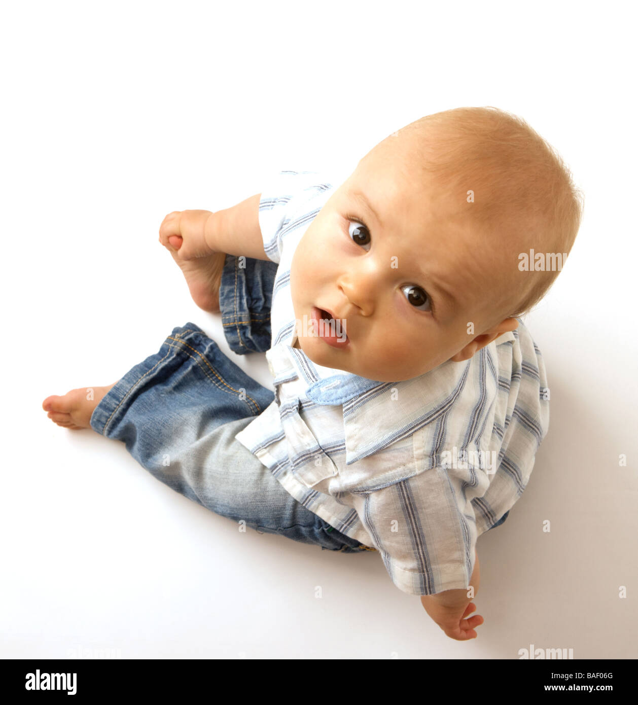 Small young boy looks up from a white background Stock Photo