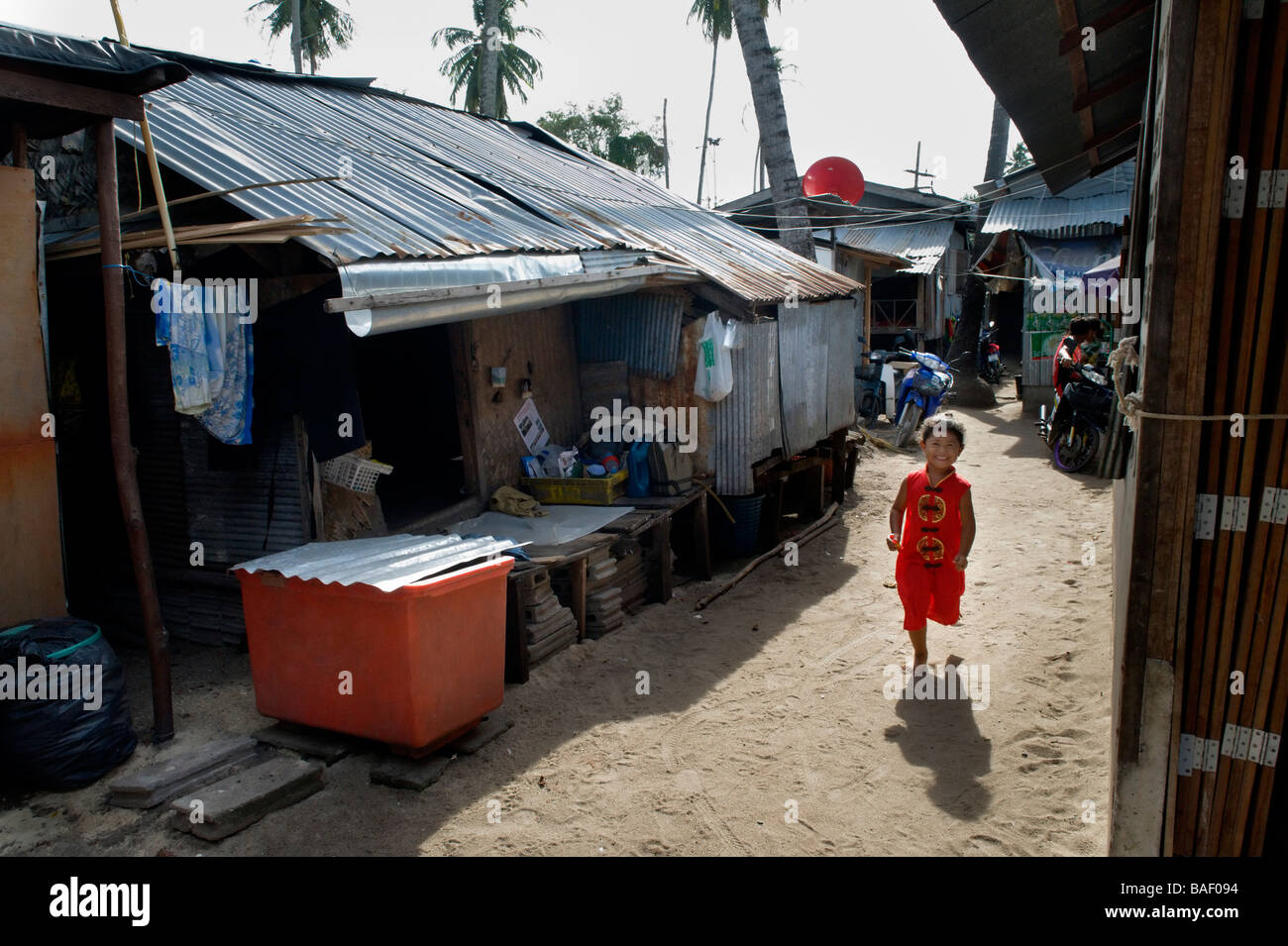 young sea gypsy girl running through a slim in Phuket south Thailand Stock Photo