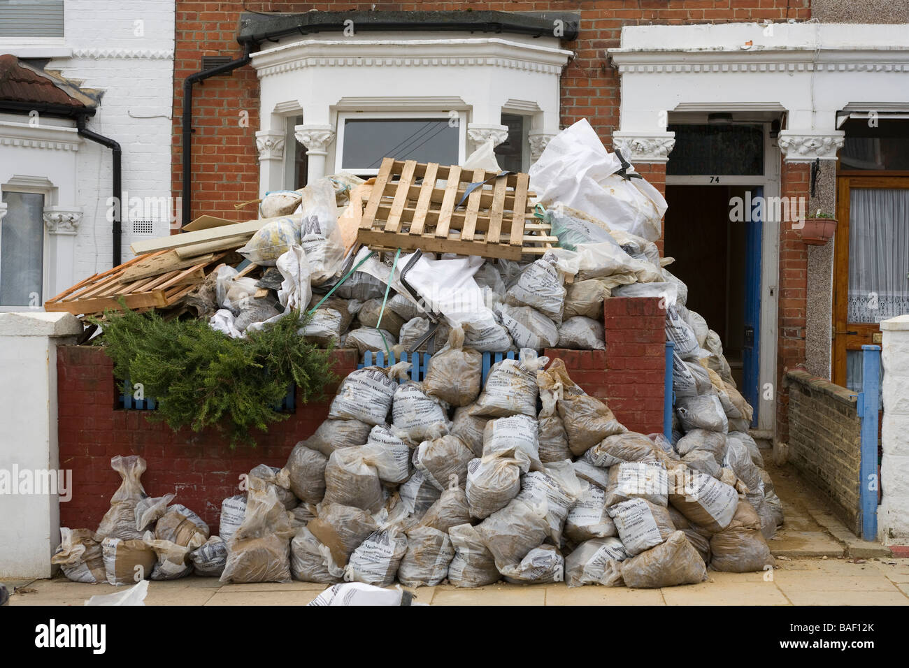 Bagged up builders rubble in sacks outside a house renovation project in south london Stock Photo