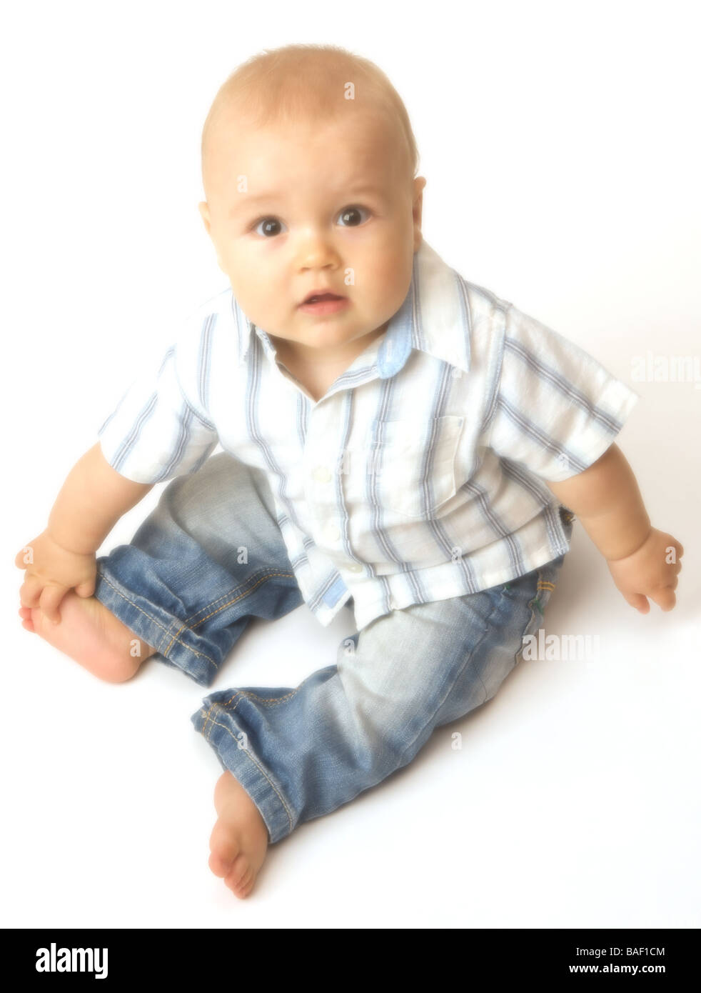 A baby looks up from a white background Stock Photo