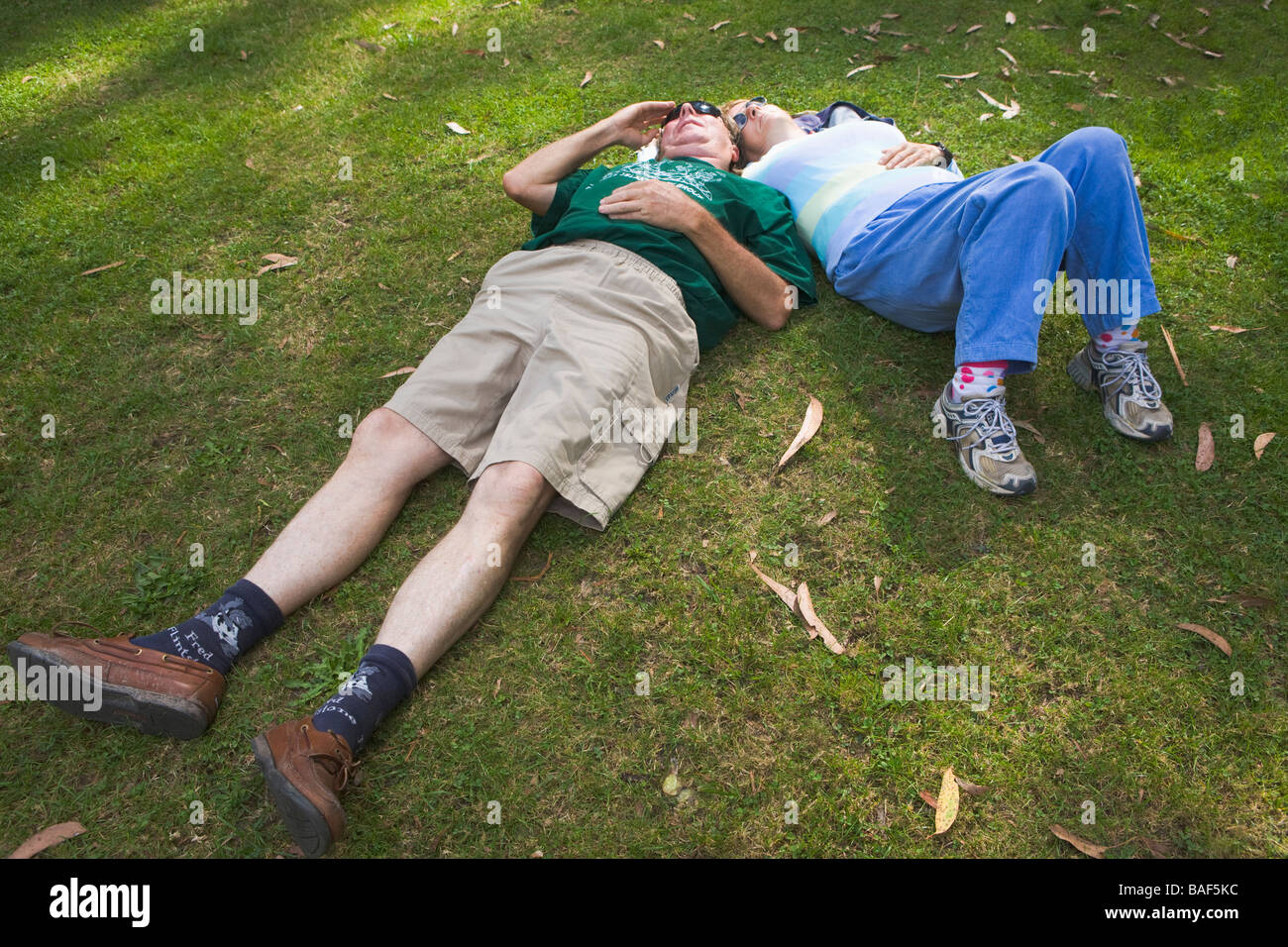 Couple relaxing on lawn Detail Stock Photo