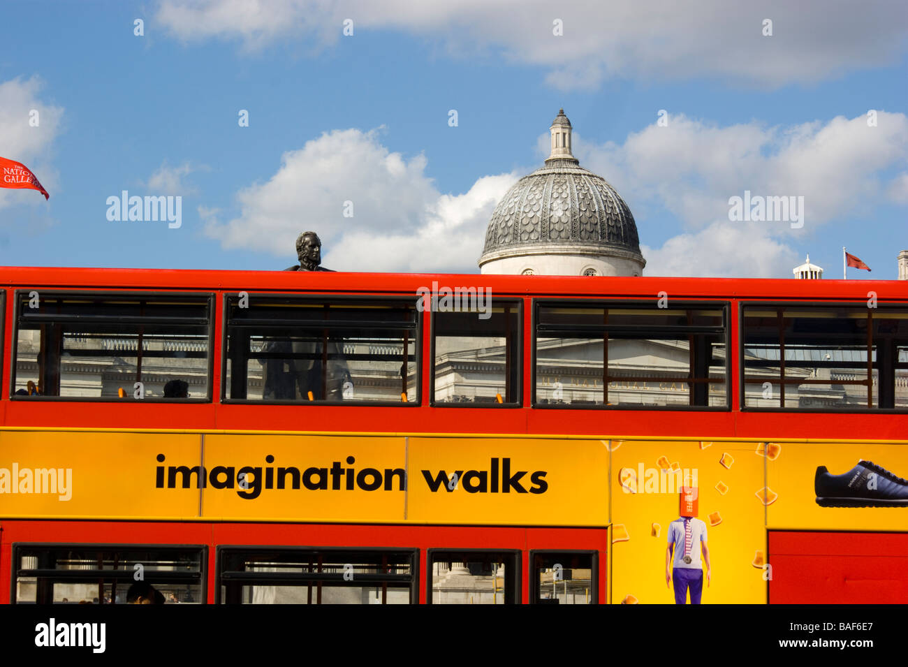 A London bus passes in front of the National Gallery in Trafalgar Square. Building is recognisable through  bus windows. Stock Photo