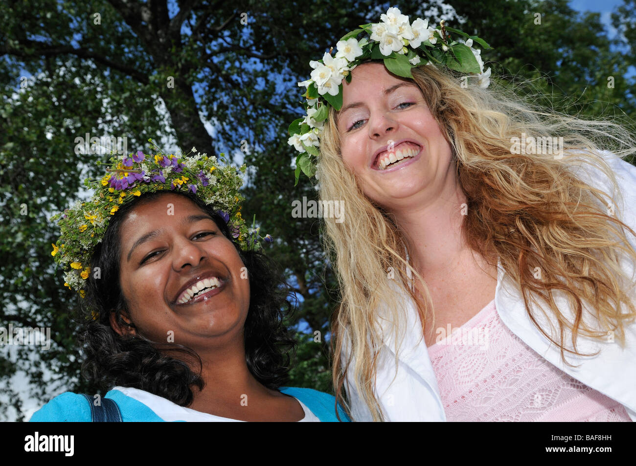 Smiling women with floral wreath at Midsummer celebration in Doessberget Sweden June 2008 Stock Photo