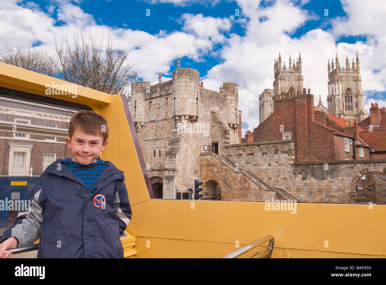 A young boy on the top deck of an open air tour bus in the city of York,Yorkshire,Uk Stock Photo