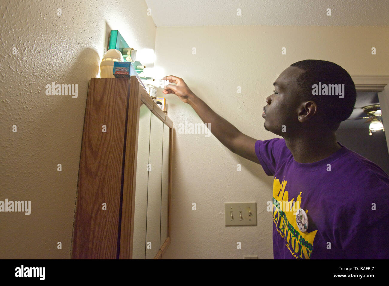 Volunteers Install Compact Fluorescent Light Bulbs Stock Photo