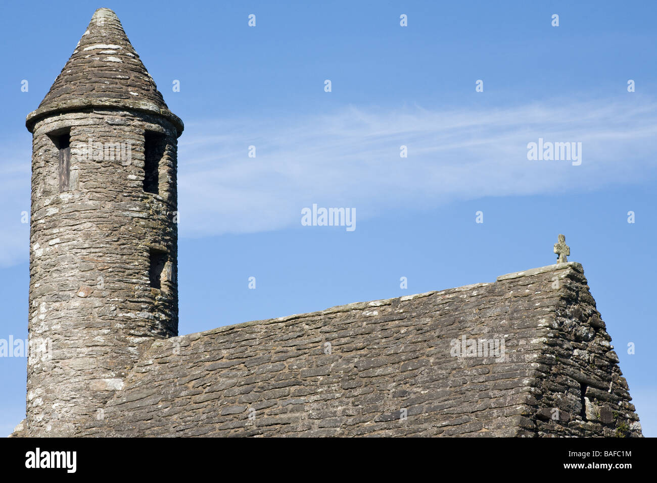 Simplicity in Stone. A detailed view of the tower and stone roof of the St Kevin's Chapel.  A rock cross adorns the roof Stock Photo