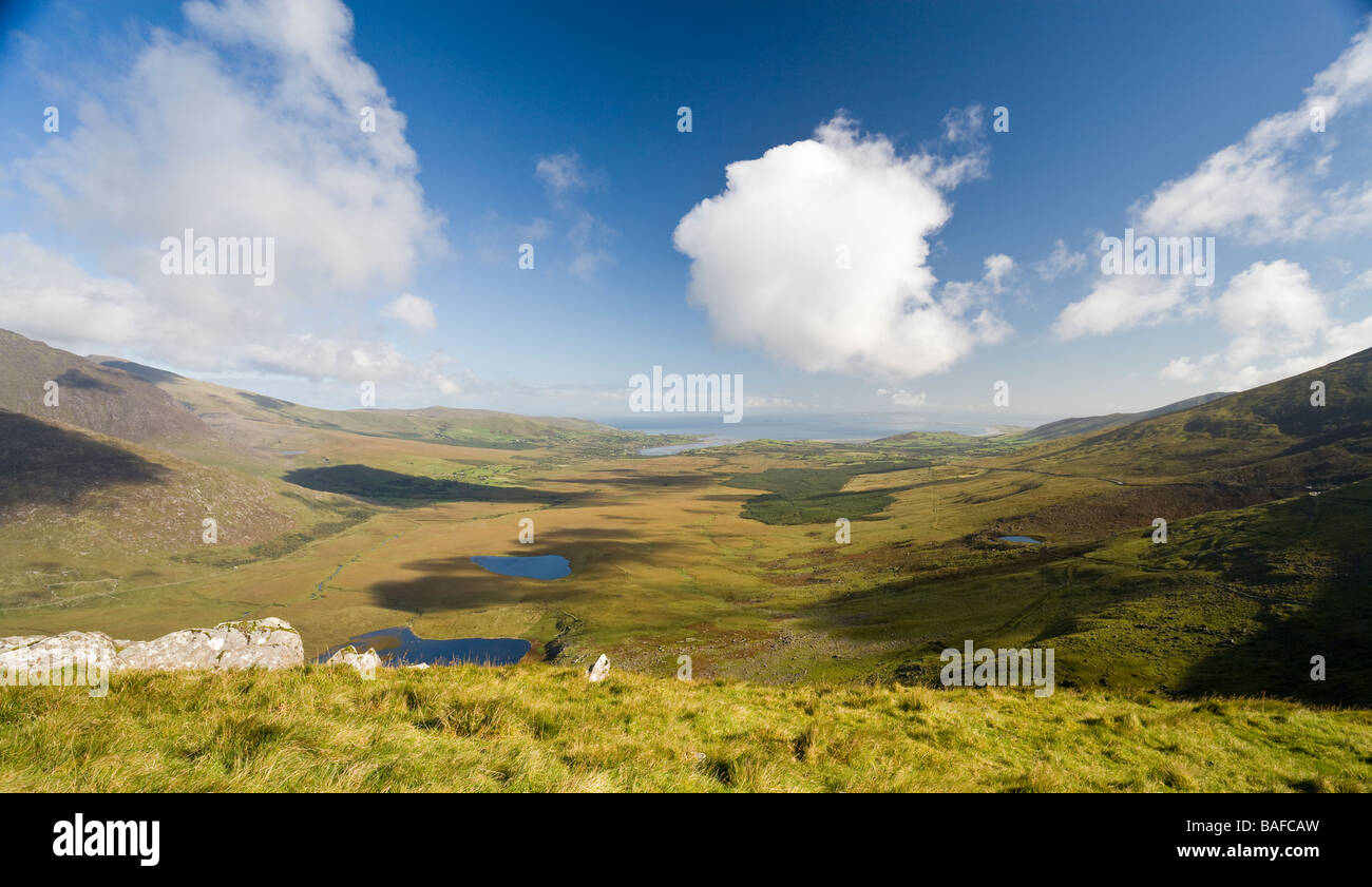 Connor Pass Clouds. Puffy white clouds float in a blue sky above the  Connor pass. The valley below is dotted with lakes Stock Photo