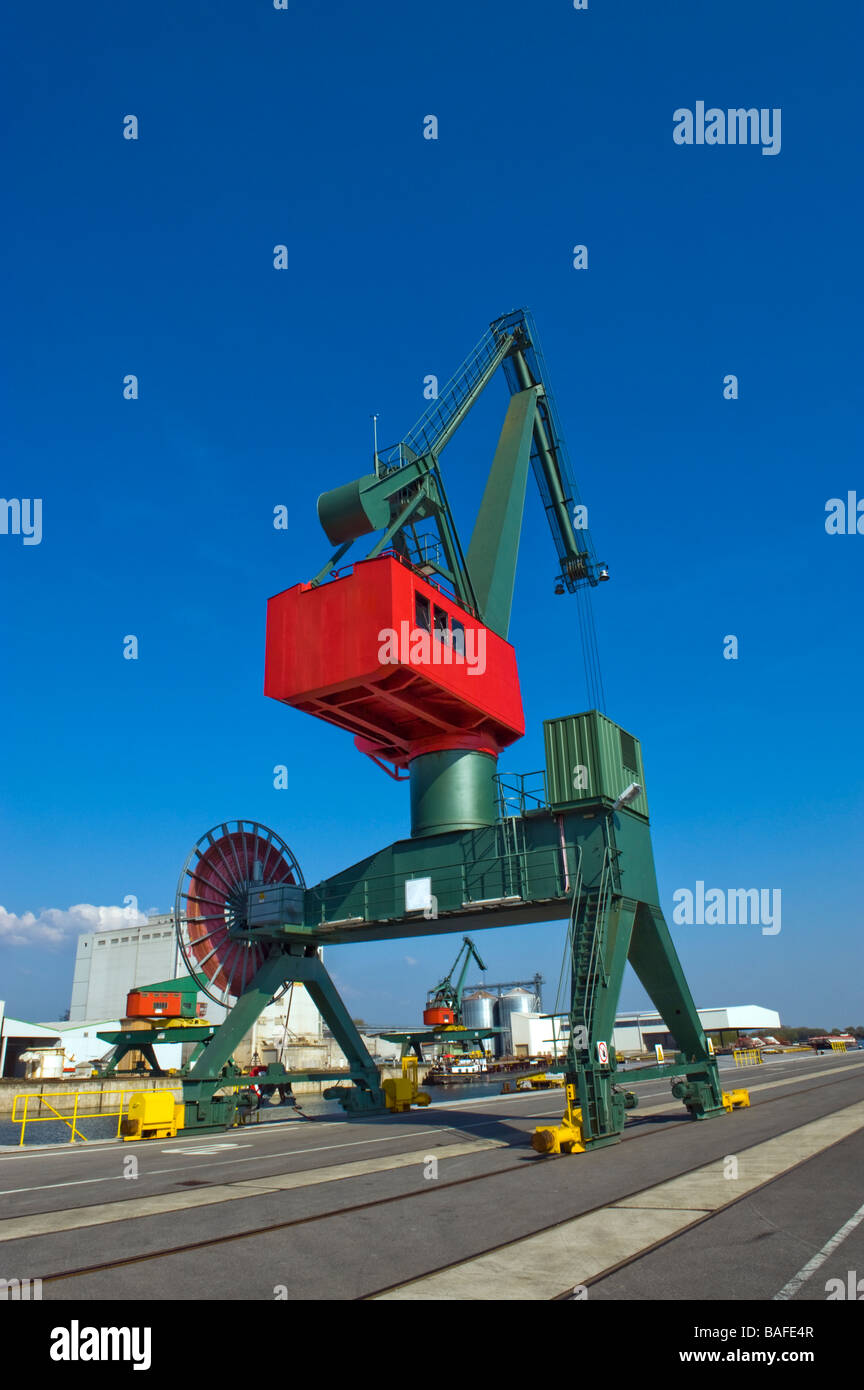 red green slewing swing CRANE in port harbor harbour reloading point  trans-shipment centre road shipment load cargo lade works Stock Photo