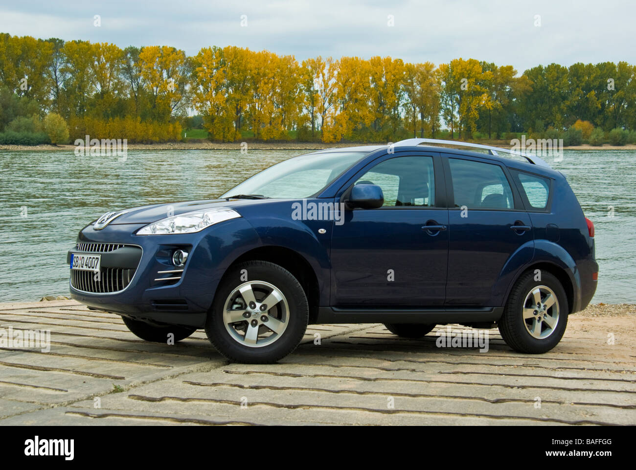 Blue Peugeot 4007 SUV at Rhine river side view Stock Photo