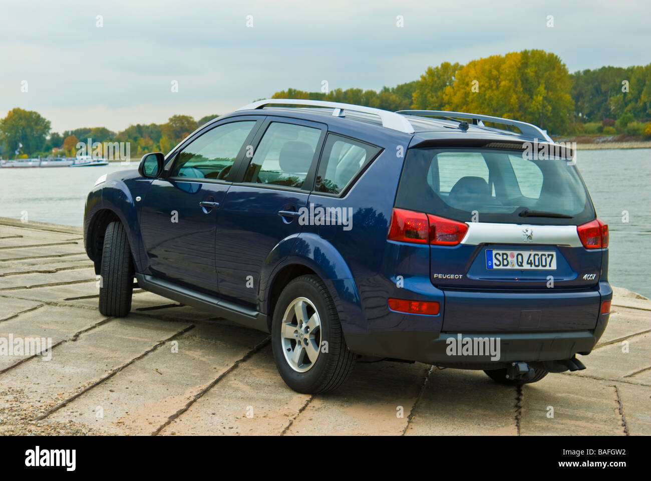 Blue Peugeot 4007 SUV at Rhine river rear view Stock Photo