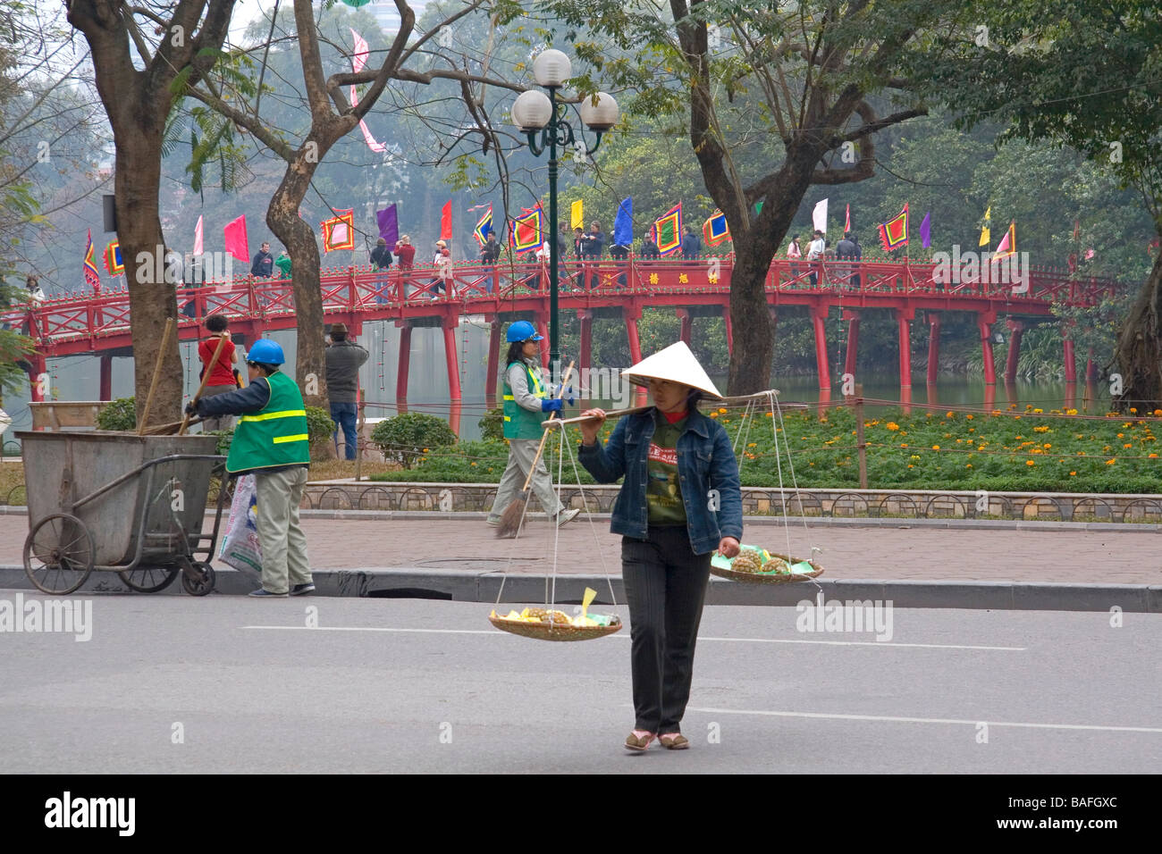 Street vendor in front of the Huc Bridge on Hoan Kiem Lake in Hanoi Vietnam Stock Photo