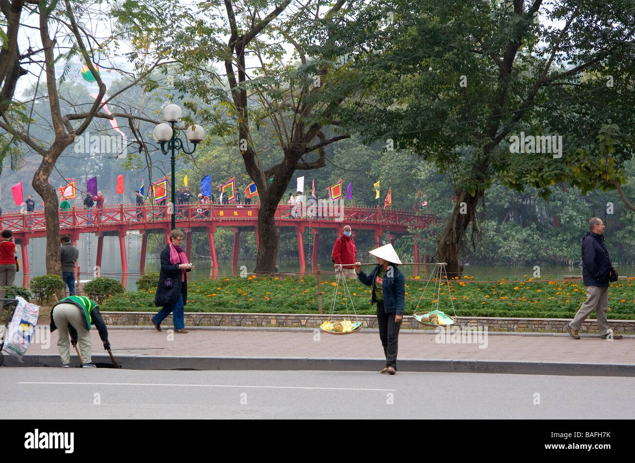 Street vendor in front of the Huc Bridge on Hoan Kiem Lake in Hanoi Vietnam Stock Photo
