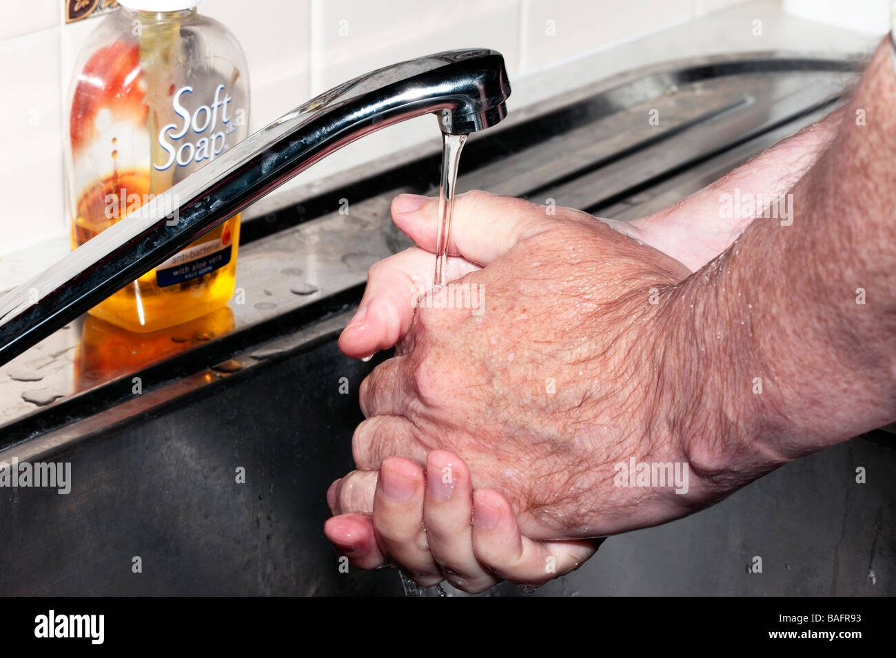 Man Washing hands in running water over kitchen sink Stock Photo - Alamy