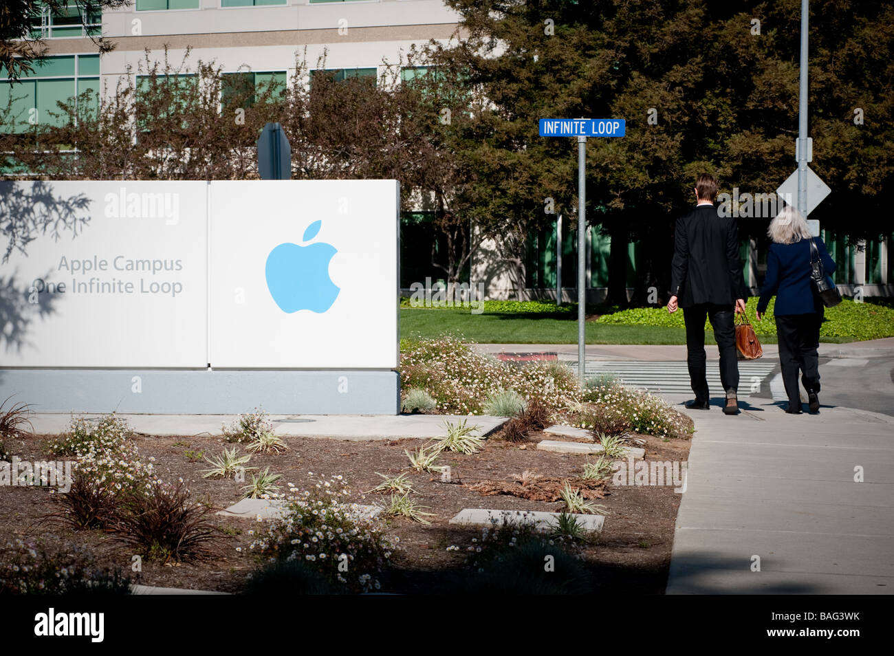 Sign at the font of the Headquarters of Apple Computer Inc.with two employees walking past. Stock Photo