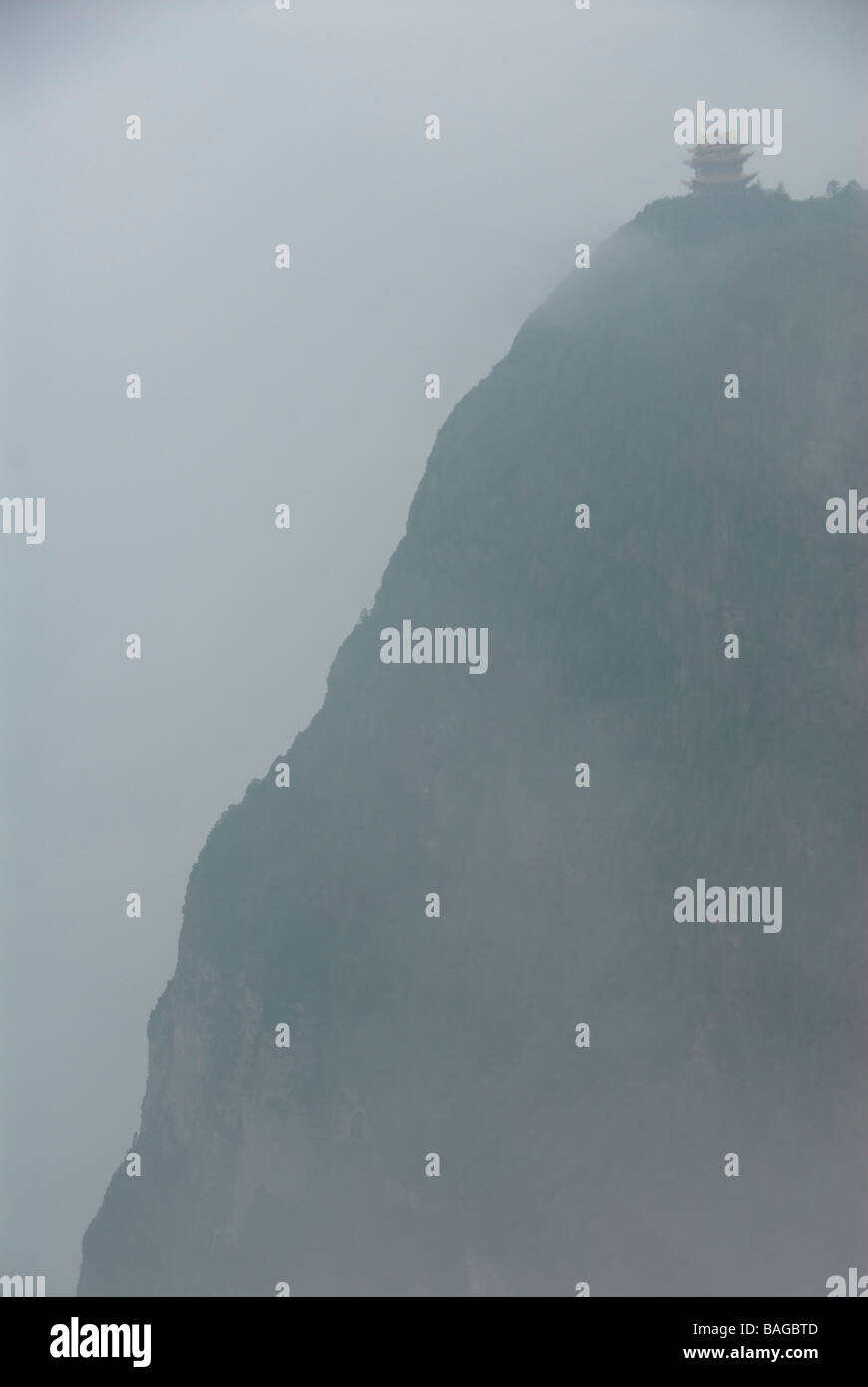 view of a cliff with Buddhist temple surrounded by clouds and mist Mt Emei Shan Sichuan China Stock Photo