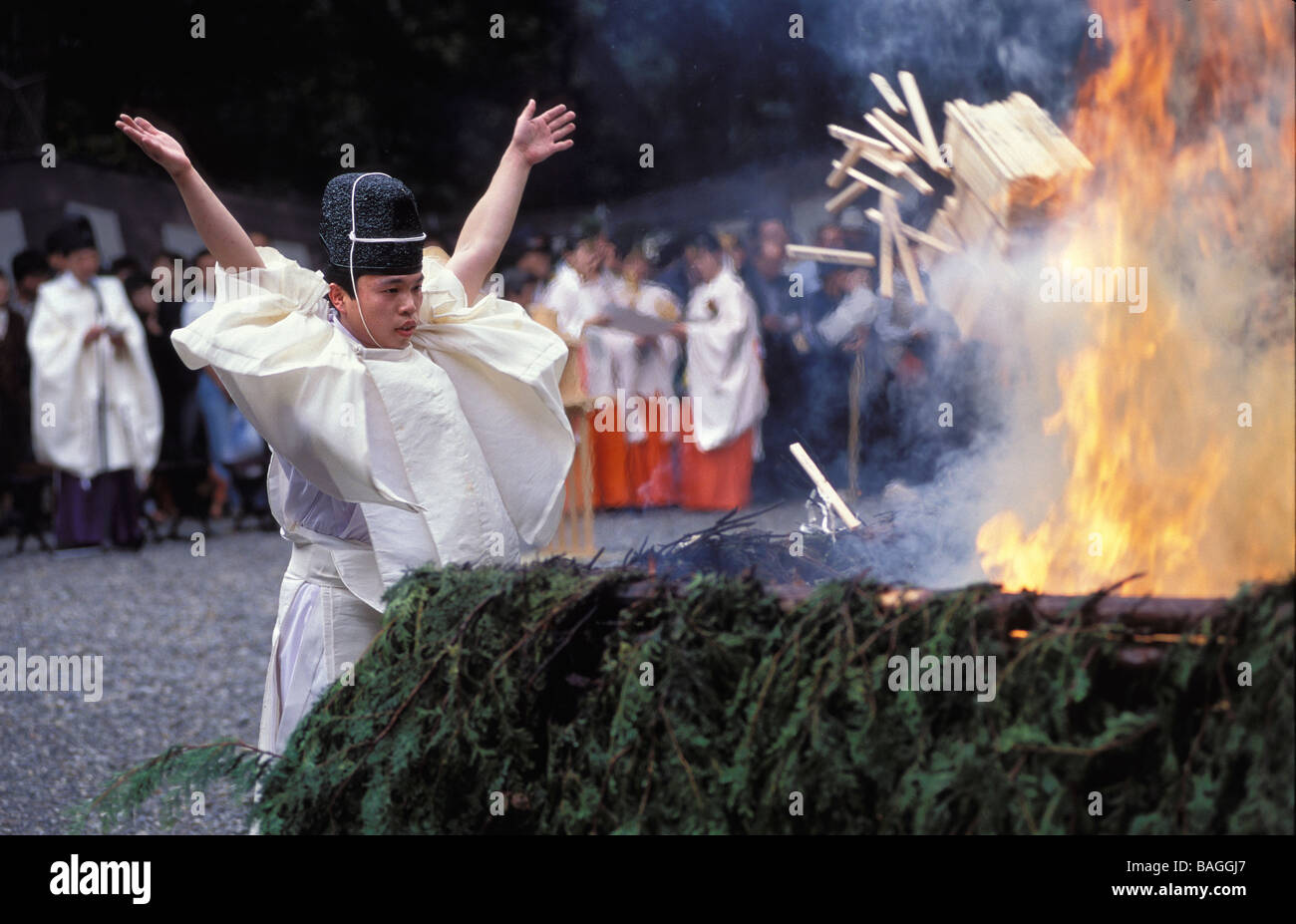 Japan, Honshu Island, Kyoto, a Shinto priest is throwing into a pyre ...