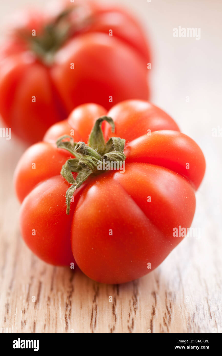 Red heirloom tomatoes on wooden background Stock Photo
