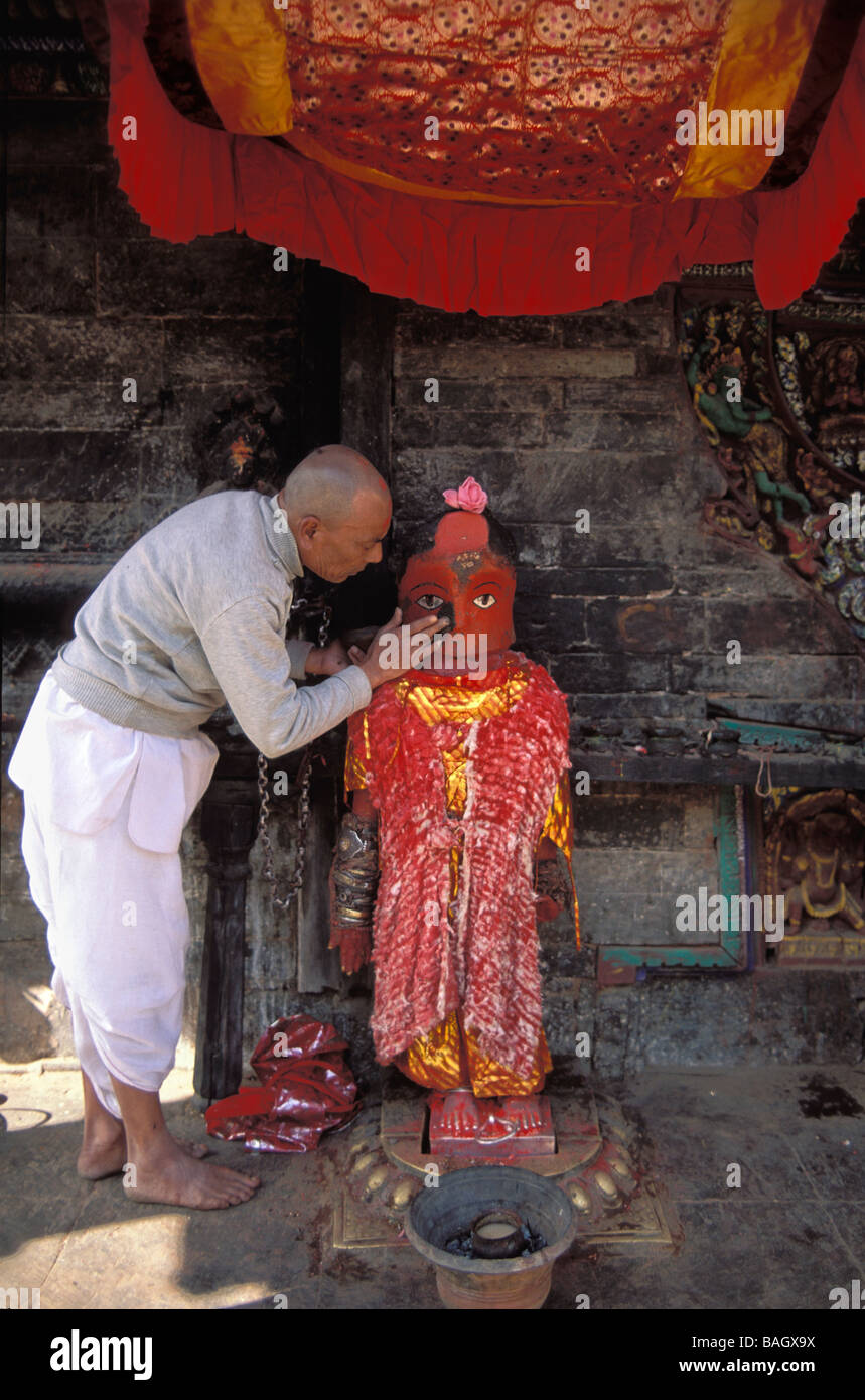 Nepal, Kathmandu Valley, Bagmati Zone, Lalitpur District, Bungamati, brahmin priest putting paste on the face of the red Hindu Stock Photo