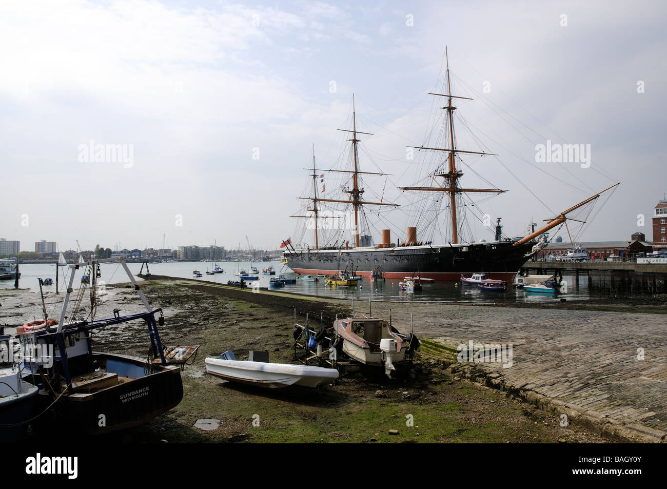 Portsmouth Harbour waterfront area HMS Warrior and small boats at low tide England UK Stock Photo