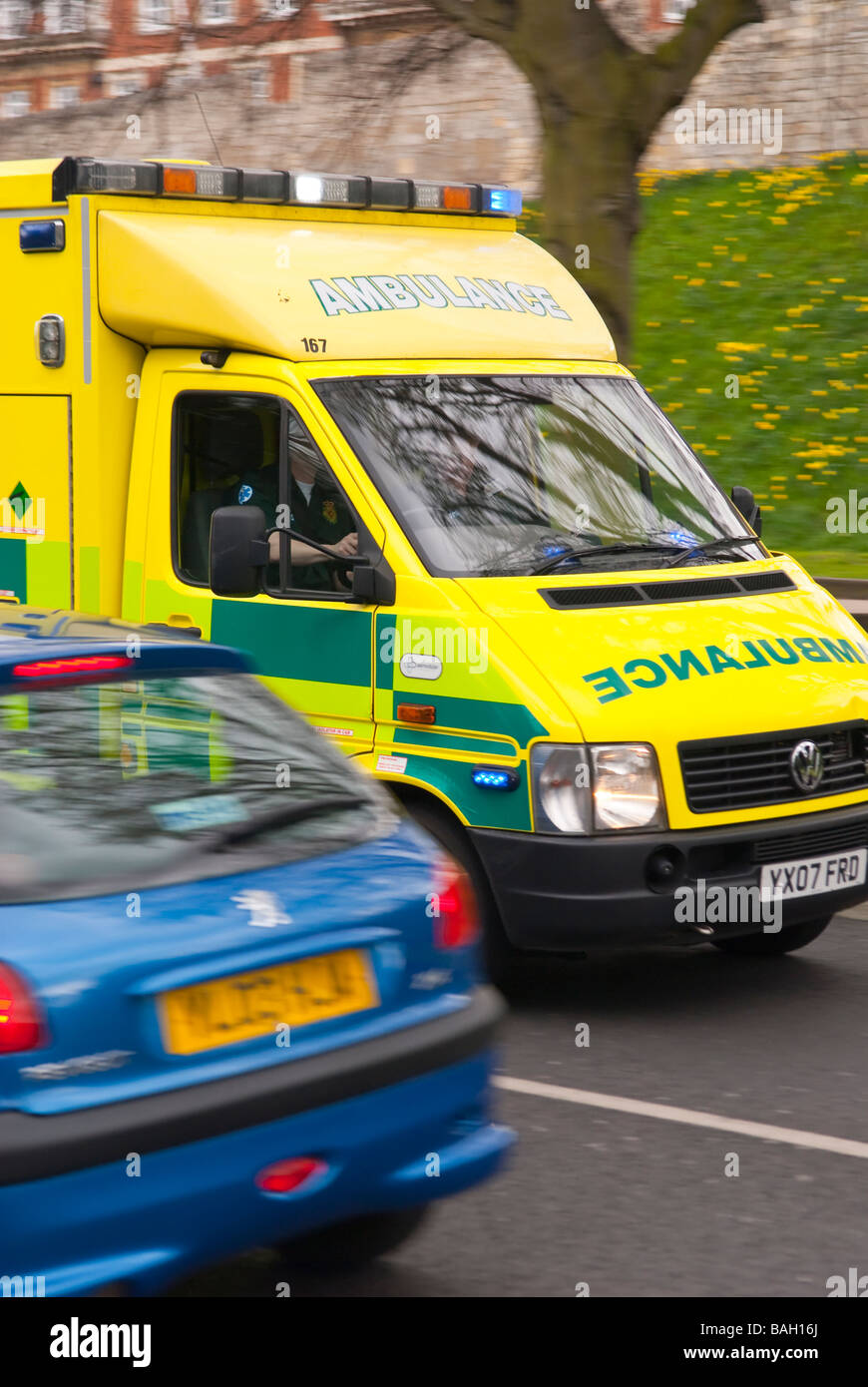 An ambulance speeding through the traffic on route to an emergency in the Uk Stock Photo