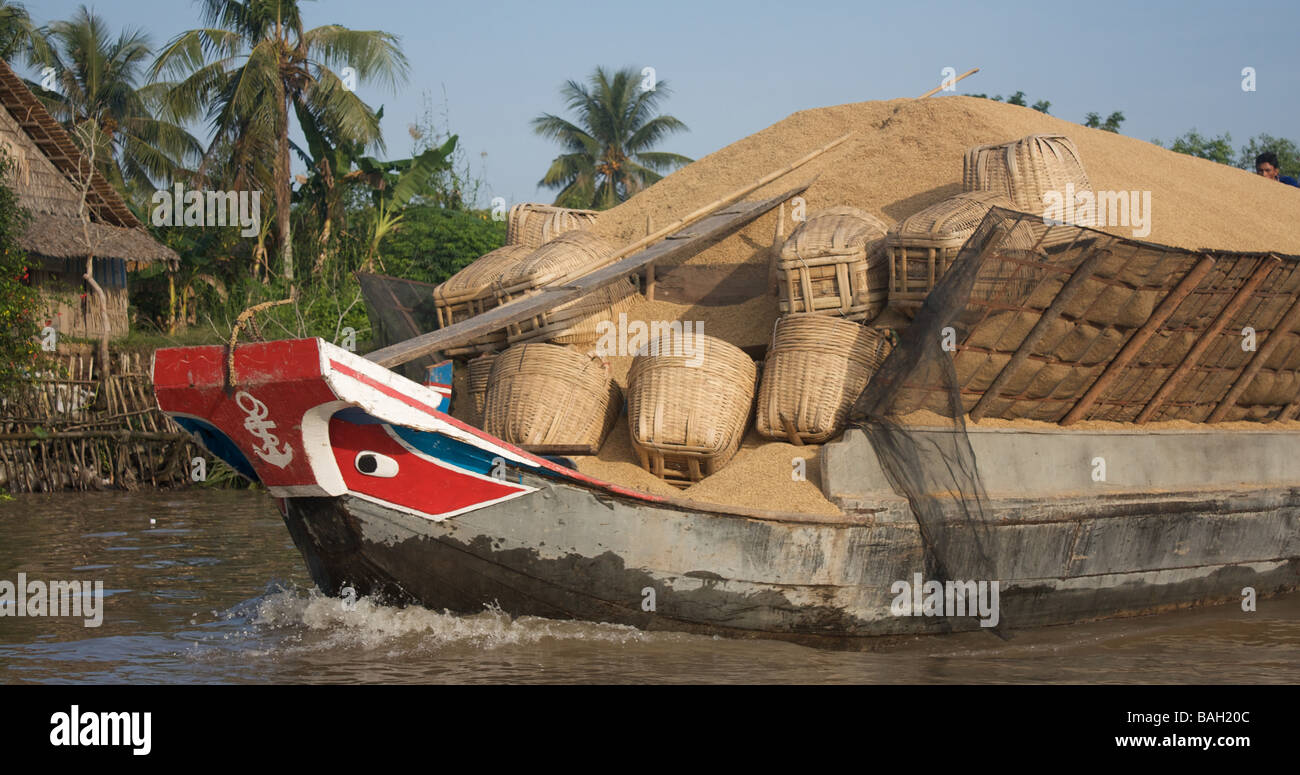 Mekong delta boat transporting rice husks near Vinh Long, Vietnam Stock Photo