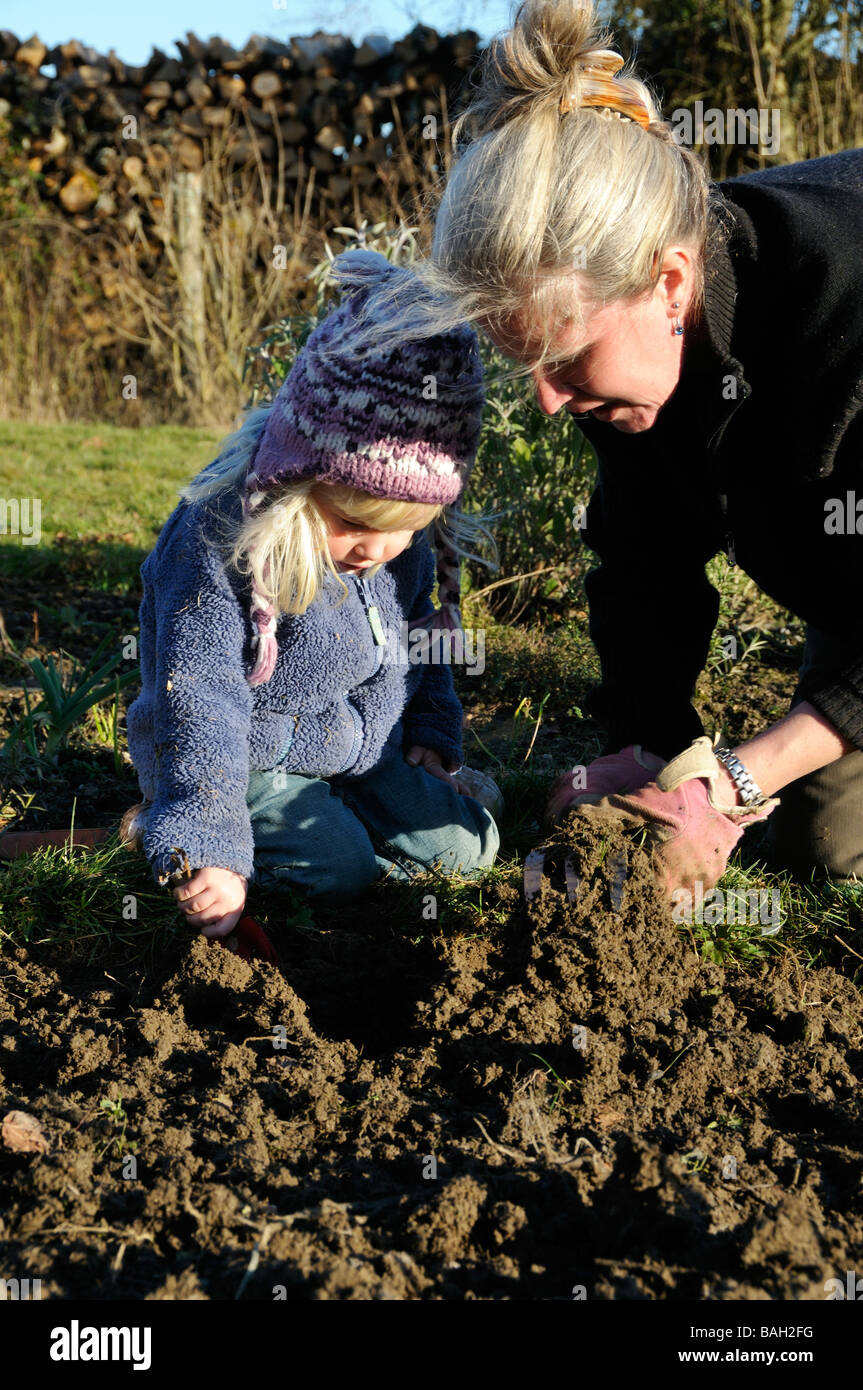 A 3 year old girl helping her mother weeding the garden Stock Photo - Alamy