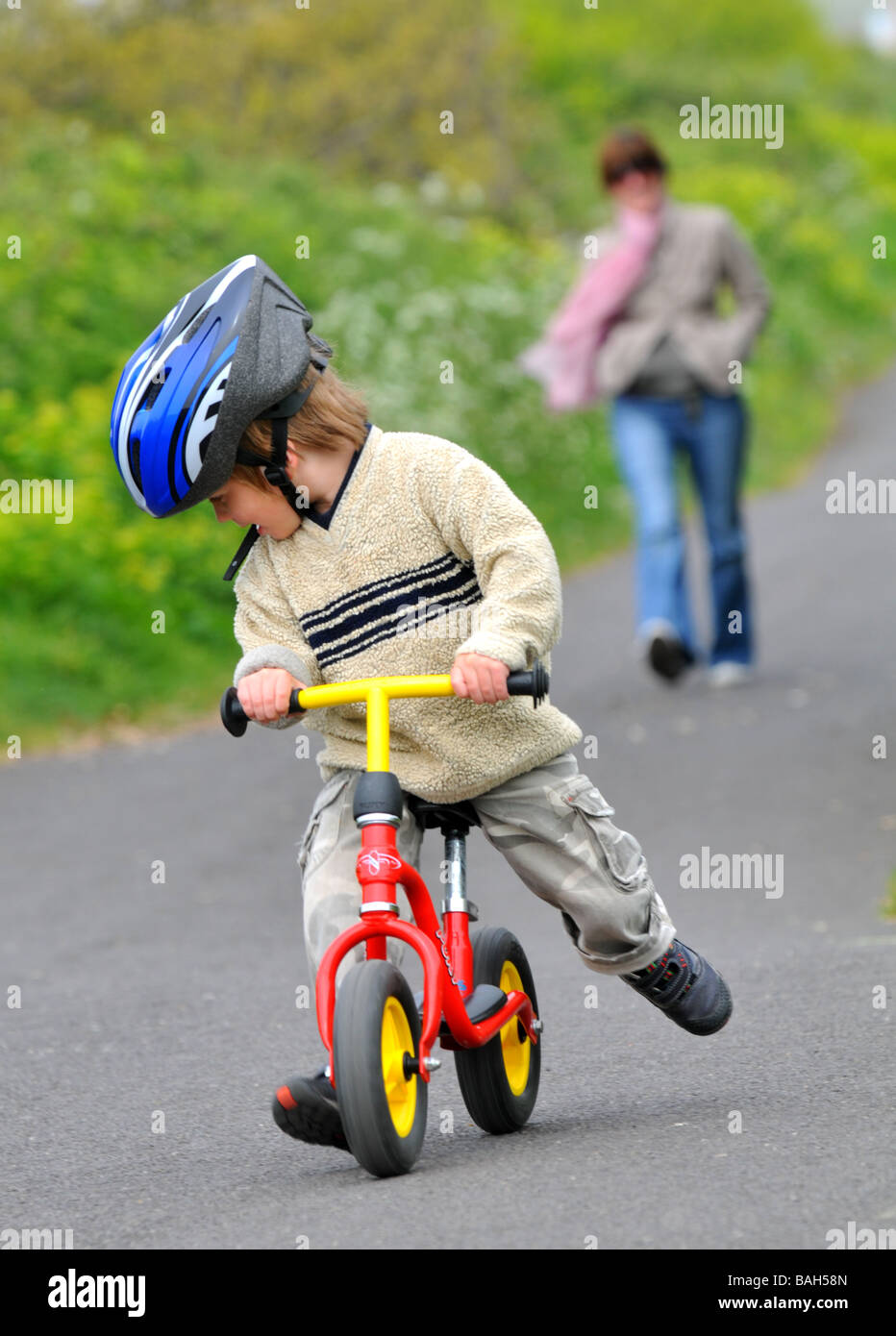 Boy learning to ride a balance bike Stock Photo Alamy