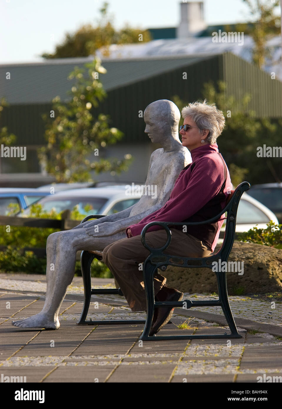 woman and statue on bench outside Hallgrímskirkja, Reykjavik, Iceland Stock Photo