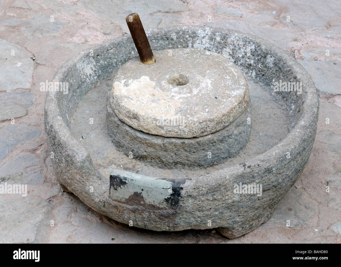 An ancient sandstone quern stone (the lower stone) and handstone (the upper one) used for grinding grain into flour. Stock Photo