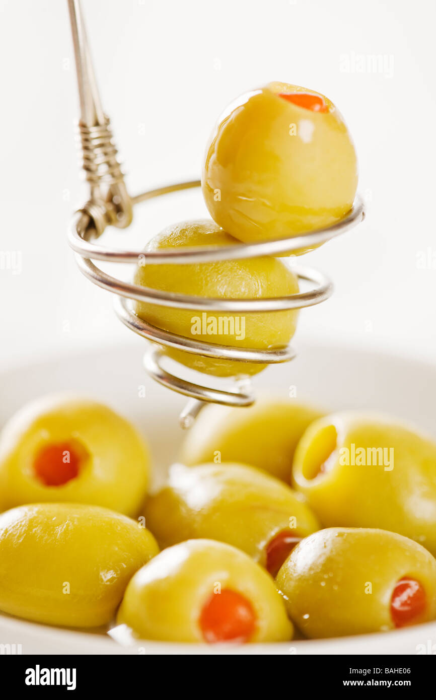 Green olives stuffed with pimentos in serving spoon Stock Photo