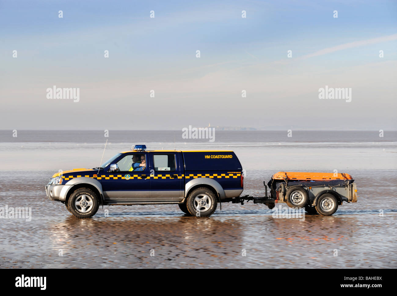 A COASTGUARD VEHICLE CROSSING THE SAND ON THE BEACH AT WESTON SUPER MARE SOMERSET UK Stock Photo