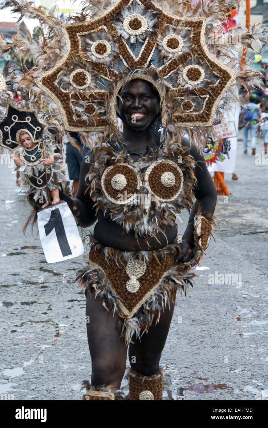 Woman in extravagant costume holding a Santo Niño figure at the Ati-Atihan festival in Kalibo, Philippines Stock Photo