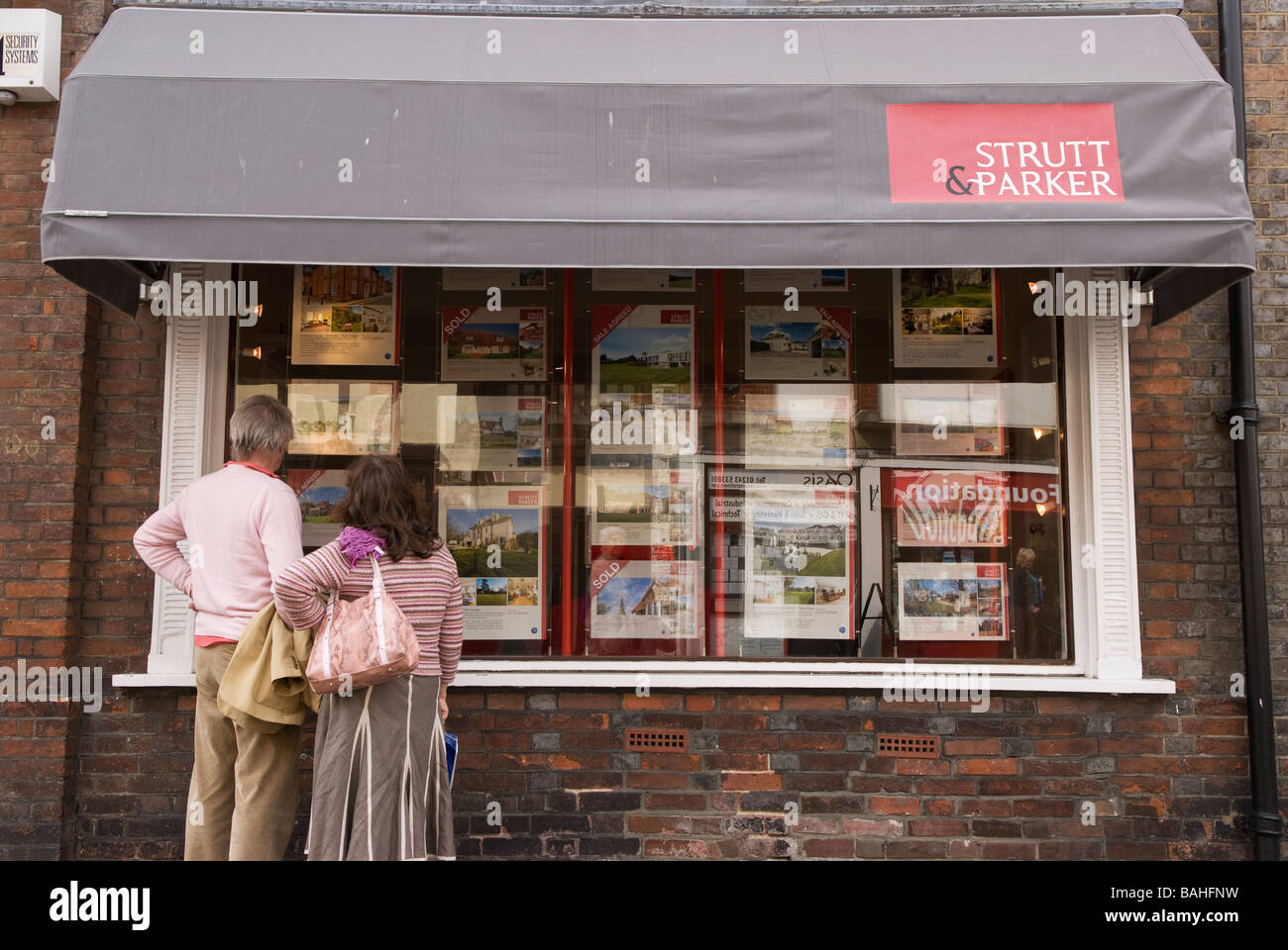 People browsing Estate Agents window display, Chichester, Sussex UK