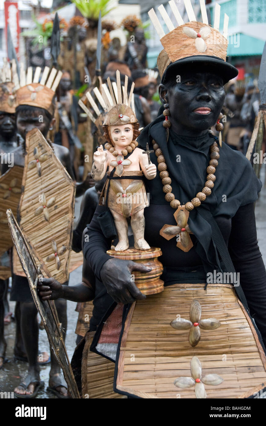 Blacked-up woman carrying Santo Niño figure at Ati-Atihan festival in Kalibo, Philippines Stock Photo