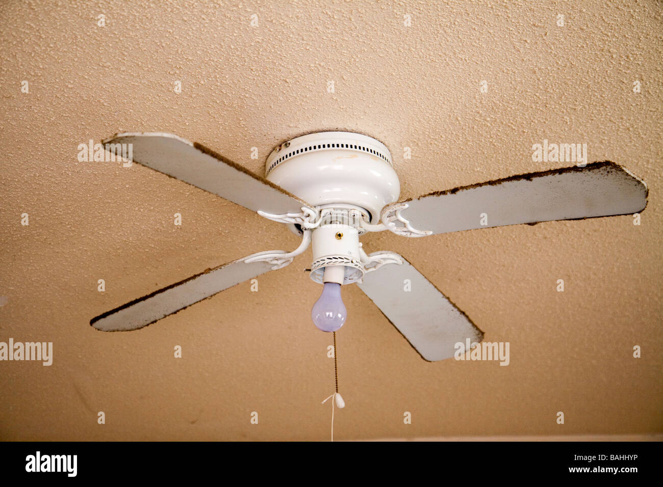 Ceiling fan in bad shape at a drug user/seller home. Stock Photo