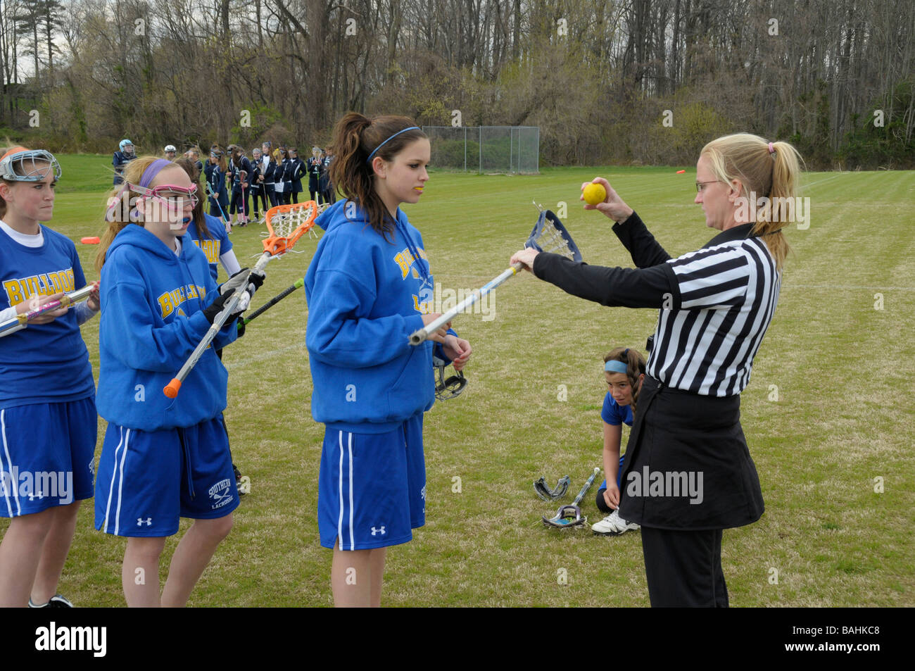 referee inspects lacrosse players raquets Stock Photo