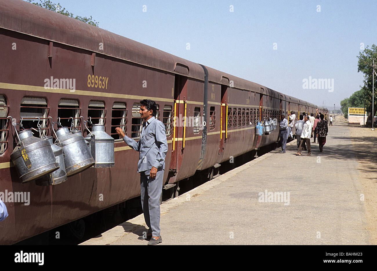Indian Railways, milk churns hung on the outside of railway carriages to keep their contents cool. Stock Photo