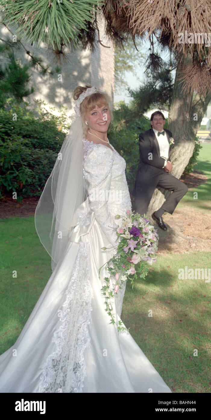 Beautiful Bride in wedding gown poses with bouquet Stock Photo - Alamy