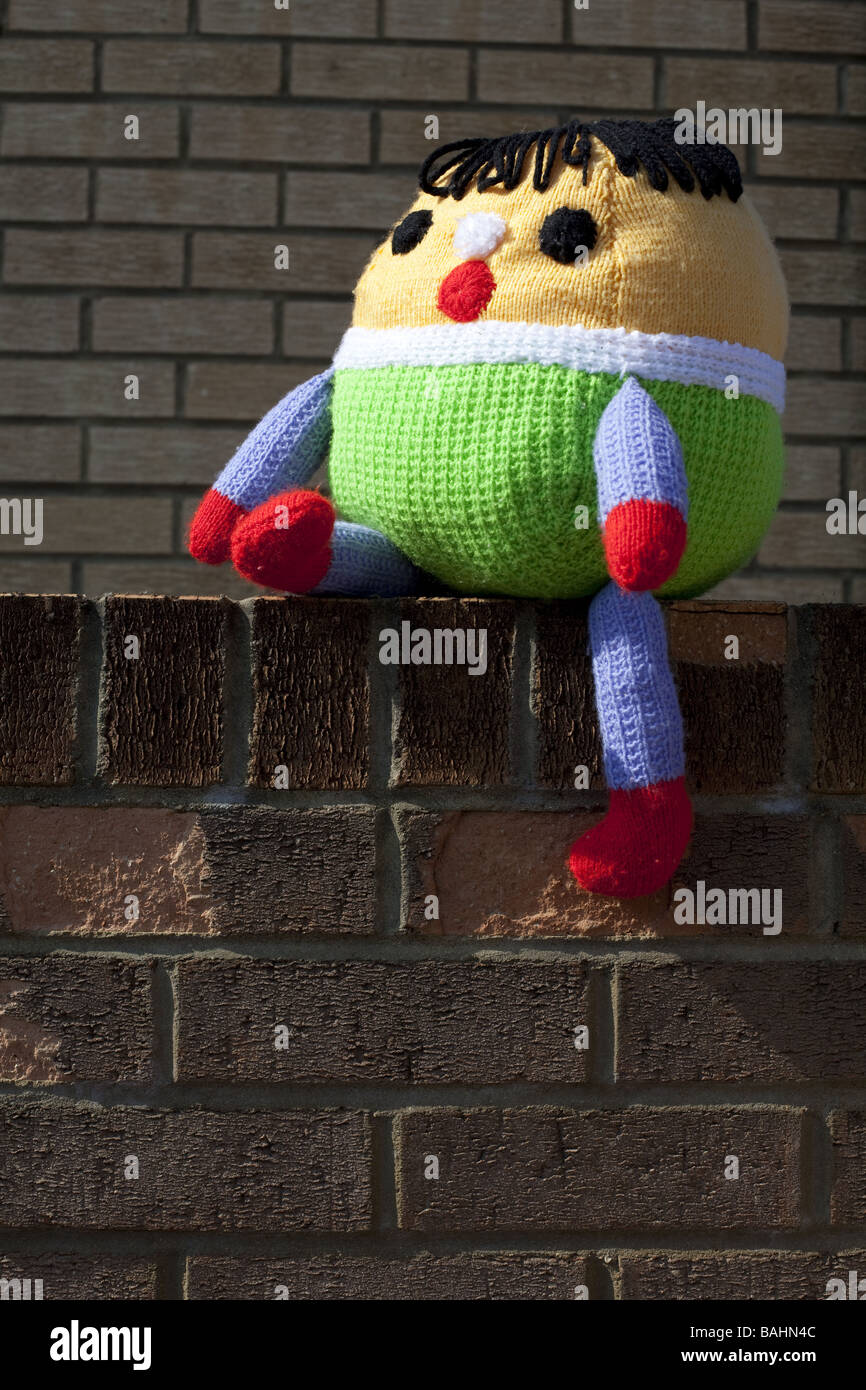 A Humpty Dumpty soft toy  sat on the wall Stock Photo